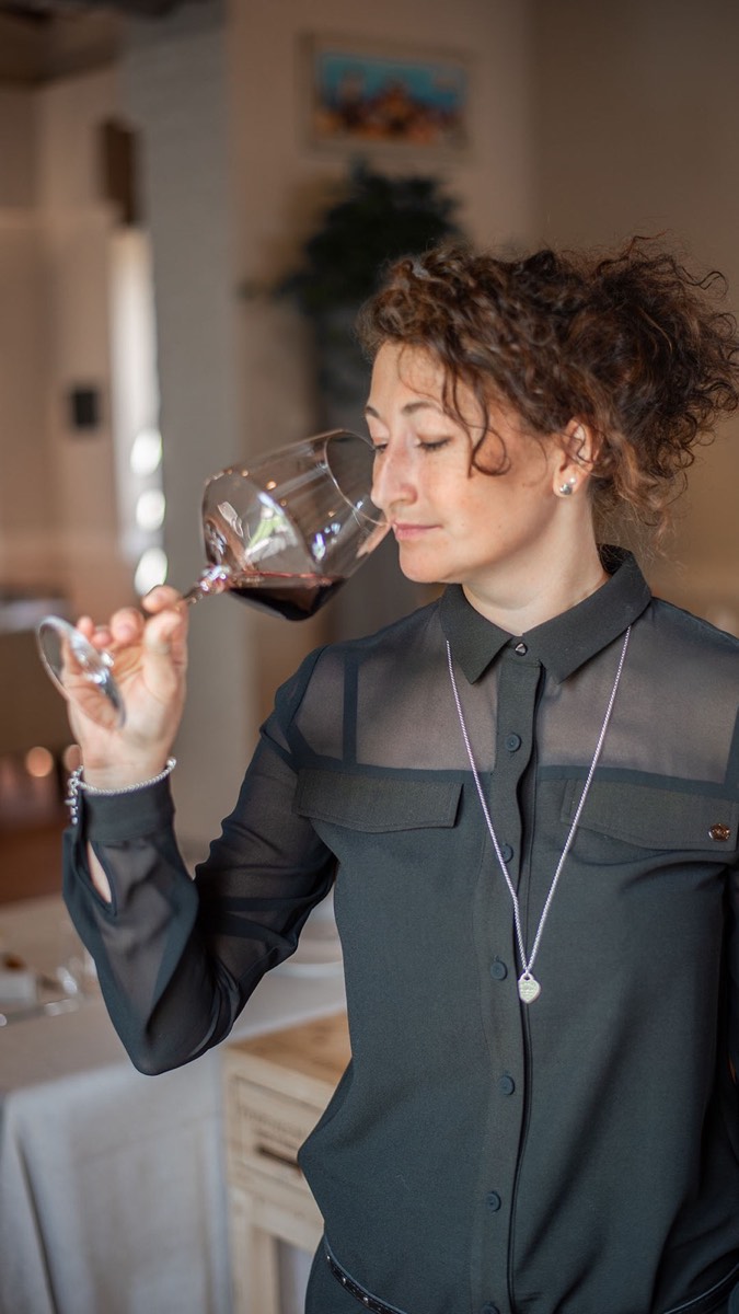 La sommelier Michela Bigio degusta un vino rosso in sala