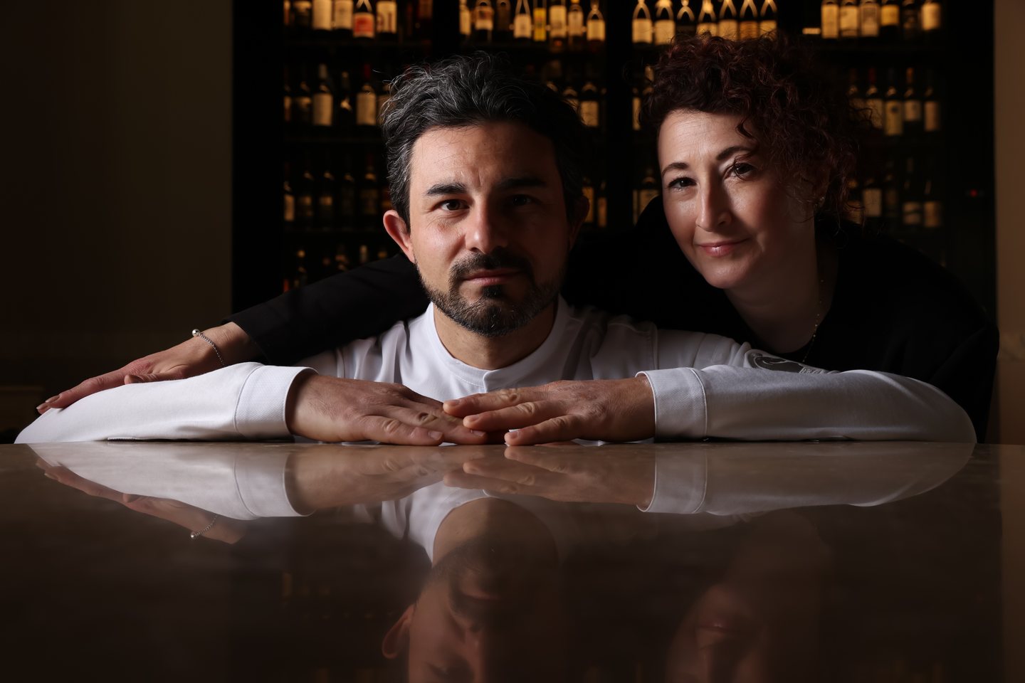 Leonardo Fiorenzani and Michela Bigio in front of the stone wall of the restaurant