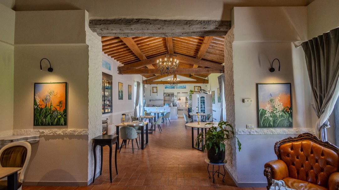 La sala interna, con il tavolo apparecchiato e le opere d’arte alle pareti