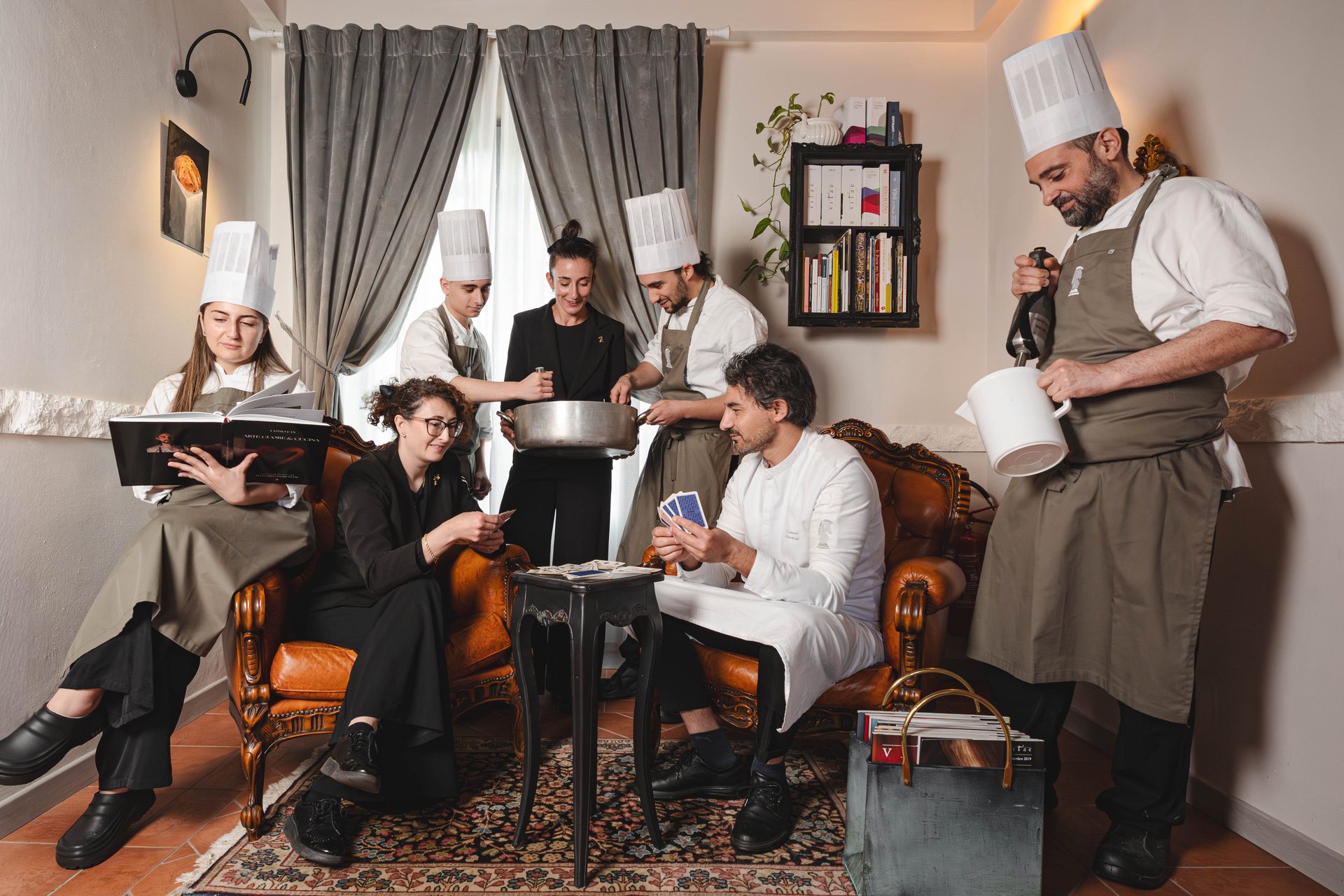 The kitchen and dining-room brigade of La Sosta del Cavaliere in the dining room, among leather armchairs and artworks on the walls
